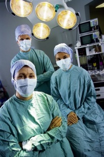 Three members of the surgical staff, in masks and gowns